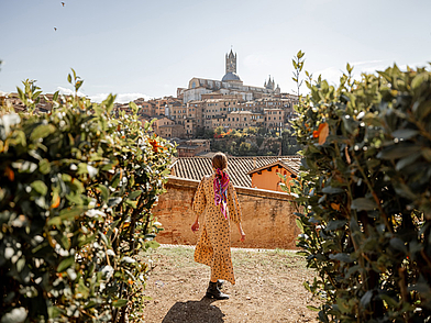 Frau blickt auf die Altstadt von Siena mit Dom im Hintergrund – authentisches italienisches Flair während einer Sprachreise erleben.