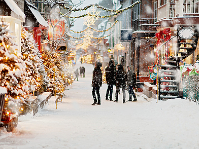 Verschneite, festlich geschmückte Straße in der Altstadt von Québec – Winterstimmung, die viele Sprachreisende begeistert.