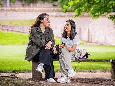 Zwei Jugendliche unterhalten sich im Grünen während ihres Junior Deutschkurses an der FU Heidelberg