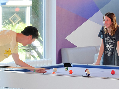 Schüler spielen Billard im Freizeitbereich des Humboldt-Instituts Bad Schussenried