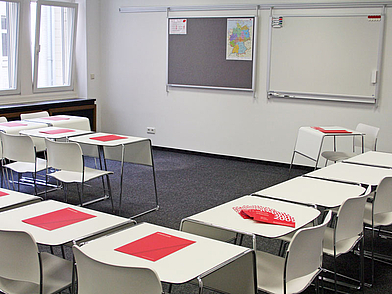 Klassenzimmer mit hellen Tischen und Lehrmaterialien für Deutsch lernen in Hamburg