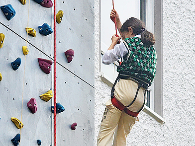 Kind beim Klettern an der Kletterwand des Humboldt-Instituts Lindenberg