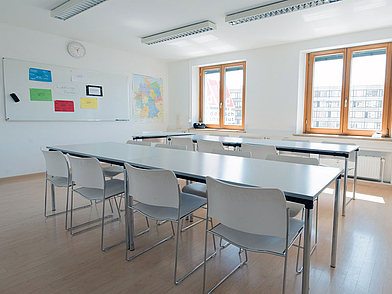 Aula luminosa con grandi finestre e attrezzature moderne per le lezioni di tedesco