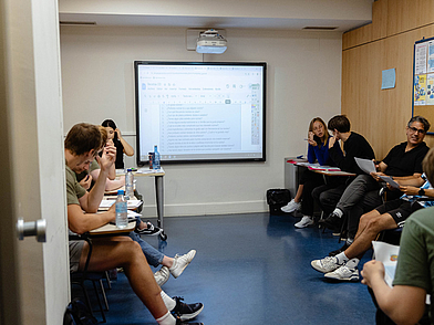 Moderne Unterrichtsräume in San Sebastián mit Beamer und interaktiven Materialien, wo Sprachschüler gemeinsam Spanisch lernen.