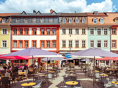 Heidelberger Marktplatz mit farbigen Fassaden und Cafés – entspannter Lernort für Business-Deutsch-Kurse.