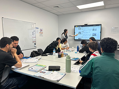 Lehrerin erklärt Grammatik auf dem Smartboard während des Englischunterrichts in Queenstown.