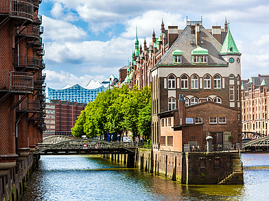 Blick auf das Wasserschloss in der Hamburger Speicherstadt mit der Elbphilharmonie im Hintergrund – Deutschkurs Hamburg für Erwachsene