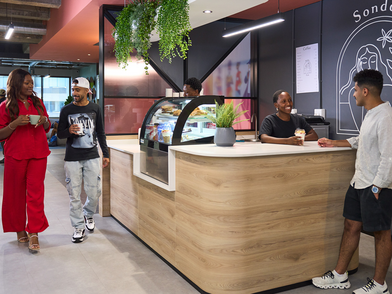 Cafeteria der Sprachschule mit Studenten, die sich unterhalten und Kaffee trinken