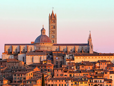 Abendliches Panorama von Siena mit Dom und Kuppel im goldenen Sonnenlicht – traumhafte Kulisse für einen Sprachaufenthalt in der Toskana.