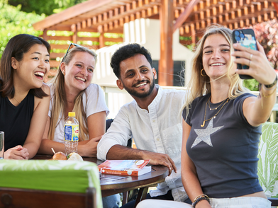 Internationale Sprachschüler genießen ihre Zeit in Kapstadt und machen gemeinsam ein Selfie in entspannter Atmosphäre.