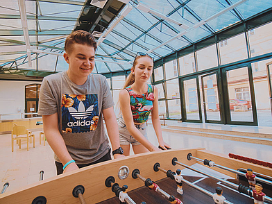 Teilnehmer am Schüler Sprachaufenthalt Wien spielen Tischfussball in der Freizeit.