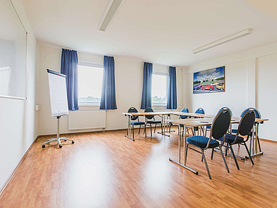 Heller Unterrichtsraum mit modernen Tischen und Stühlen für kleine Lerngruppen