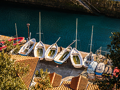 Kleine Segelboote am Hafen von San Sebastián, die im klaren Wasser liegen – ein authentischer Eindruck des maritimen Flairs während einer Sprachreise nach San Sebastián.