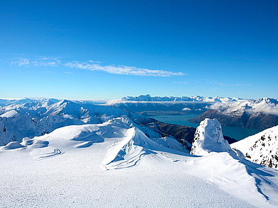 Verschneite Berggipfel bei Queenstown mit Blick auf den See – Sprachreise nach Neuseeland mit Naturerlebnis