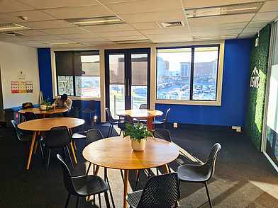 Heller Aufenthaltsraum mit Sitzplätzen und Ausblick bei der LSNZ Sprachschule Queenstown.