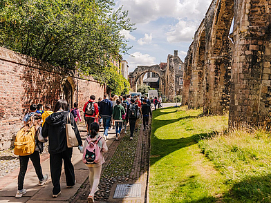 Gruppe von Sprachschülern unternimmt einen Ausflug durch die alten Mauern und Gassen von Canterbury, Teil des kulturellen Rahmenprogramms der Sprachschule.
