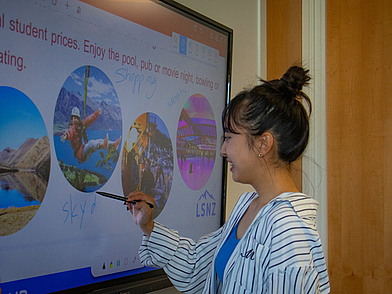 Schülerin schreibt Vokabeln an das digitale Whiteboard im Englischunterricht in Queenstown.