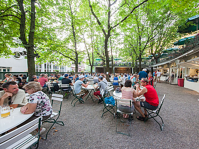 Sommerlicher Biergarten in Freiburg, wo Sprachschüler nach dem Deutschkurs entspannen und Kontakte knüpfen können.