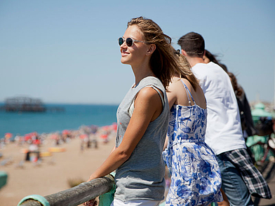 Une participante à un séjour linguistique d'anglais admire la vue sur la plage de Brighton