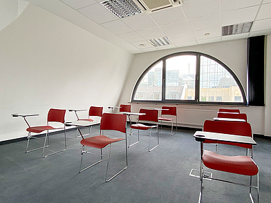 Unterrichtsraum mit großem Rundbogenfenster in der Sprachschule Frankfurt