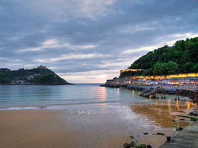 Die berühmte Bucht La Concha in San Sebastián im Abendlicht, mit Blick auf Strand, Promenade und die umliegenden Hügel – ein Highlight jeder Sprachreise nach San Sebastián.