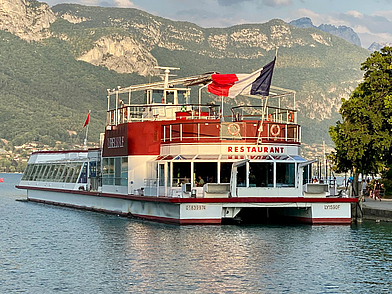 Restaurantschiff auf dem Lac d’Annecy vor Bergkulisse – Sprachreise mit Natur- und Kulturerlebnis in Frankreich