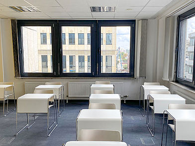 Moderner Kursraum der Sprachschule Frankfurt mit Einzeltischen und Stadtblick