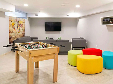 Gemeinschaftsraum der Residenz in Madrid mit Tischkicker, Sofas und Lounge-Bereich für Sprachschüler.