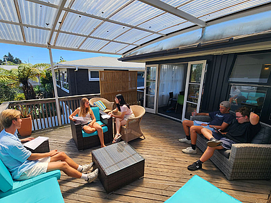 Sprachschüler beim Lernen auf der sonnigen Terrasse der Sprachschule Mount Maunganui – Englischkurs in entspannter Umgebung