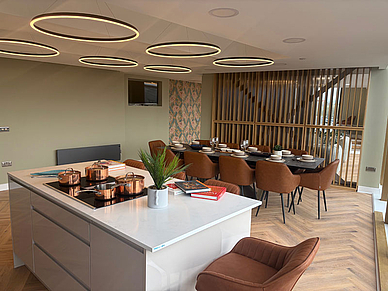 Cuisine commune lumineuse de la résidence de studios à Liverpool, avec une grande table à manger