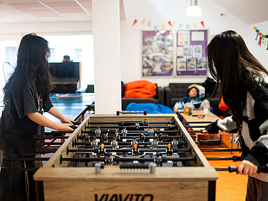 Zwei Schülerinnen spielen Tischfußball im Freizeitbereich der Sprachschule St. Giles Oxford. 