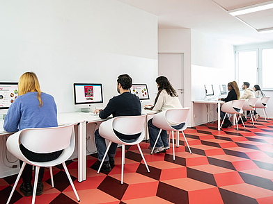 Lernende arbeiten an Computern im Selbststudienraum der Schule