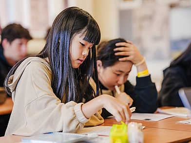 Schülerinnen konzentrieren sich im Klassenraum auf ihre Englischübungen, betreut von erfahrenen Lehrkräften der St. Giles Sprachschule.