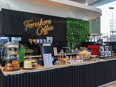 Modernes Café im Gebäude der Sprachreise-Unterkunft in Kapstadt mit Snacks und Kaffeeangebot.