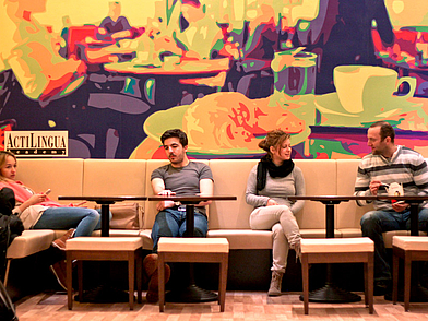 Schüler entspannen in der Lounge der ActiLingua Sprachschule Wien.