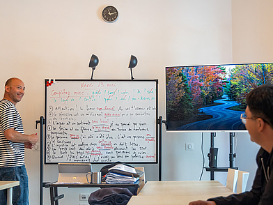 Lehrer erklärt Grammatik am Whiteboard in der Sprachschule Les Ateliers FL Biarritz – Unterricht einer Französisch-Sprachreise.