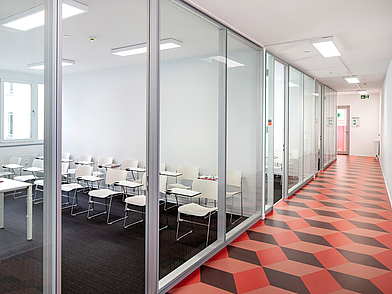 Blick in einen hellen Unterrichtsraum mit modernen Glaswänden