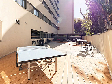 Außenterrasse der Residenz in Madrid mit Sitzbereich und Tischtennisplatte für Sprachschüler.