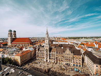 La Marienplatz di Monaco, con il nuovo municipio e la Frauenkirche, è un punto d'incontro centrale per i viaggiatori di lingua.