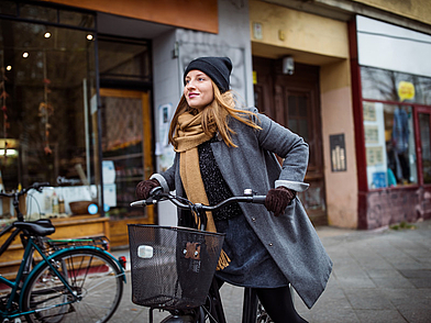 Frau fährt mit dem Fahrrad durch Berlin-Prenzlauer Berg während einer Deutsch Sprachreise für Erwachsene.