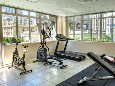 Heller Fitnessraum der Residenz mit Laufband, Fahrrad und Crosstrainer im Stadtzentrum von Kapstadt