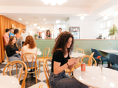 Gli studenti di lingue siedono nell'accogliente area lounge della scuola di lingue Expanish e chiacchierano davanti a un drink.