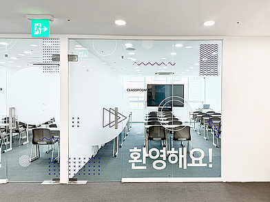 Eingangsbereich der Lexis Korean School Seoul mit modernem Klassenzimmer und begrüßender Beschriftung.