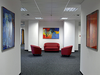 Sitzbereich mit roten Sesseln als Treffpunkt für Teilnehmende zwischen den Kursen