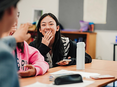 Schülerin lacht während des Unterrichts und nimmt aktiv an der Englisch Sprachreise für Jugendliche in Canterbury teil.