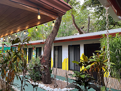 Tropischer Garten der Studentenresidenz in Sámara mit üppiger Vegetation und Außenbereichen.