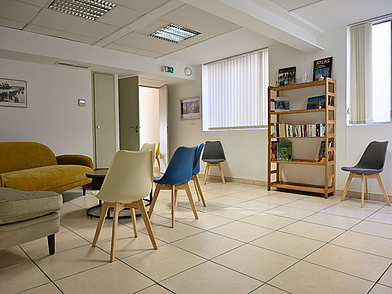 Salone della scuola di lingue di Nizza con zona salotto e libreria per gli studenti di lingue.