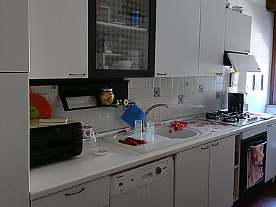 Gemeinschaftsküche mit Herd, Spüle, Schränken und Arbeitsfläche in einem Aparment.