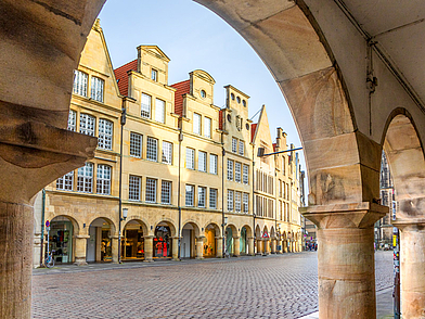 Deutsch Sprachreisen Münster für Erwachsene – Blick durch historische Bögen auf den Prinzipalmarkt mit einzigartiger Architektur
