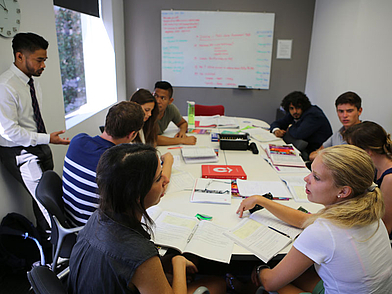 Corso intenso di inglese a San Diego: gli studenti imparano insieme in un gruppo internazionale con un insegnante alla lavagna.